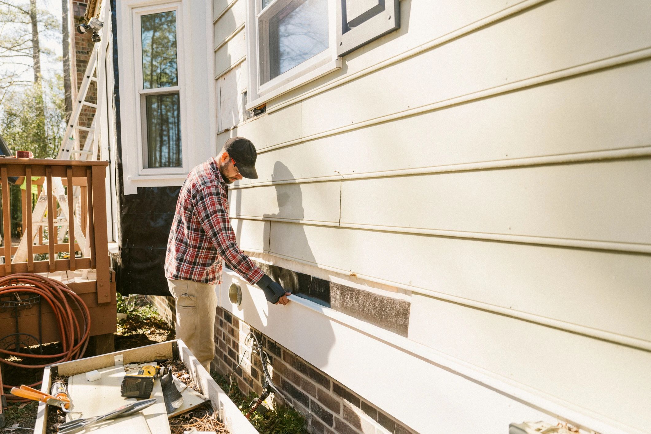 Contractor repairing storm-damaged exterior siding