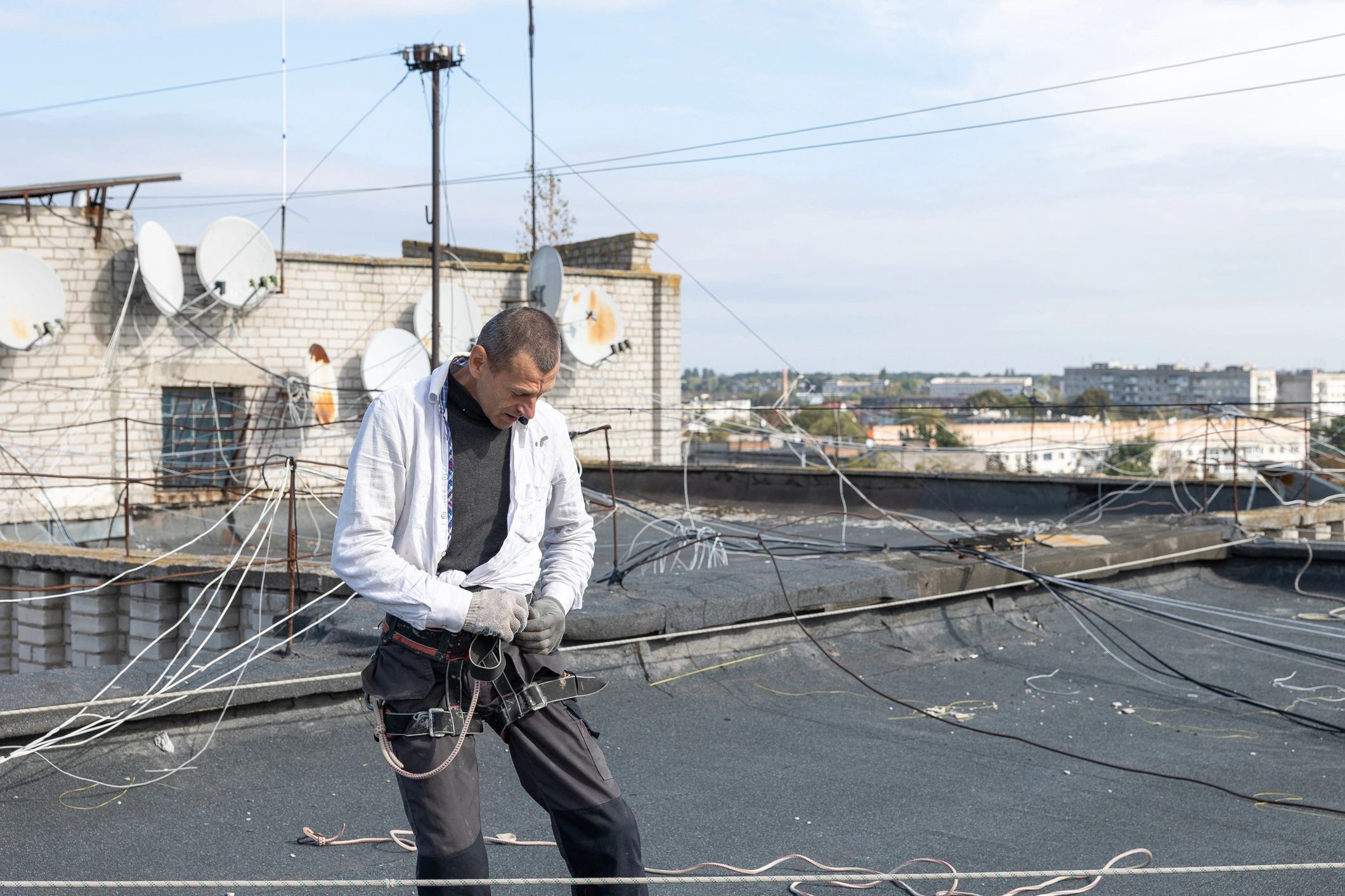 Roofer working on a roof with safety harness