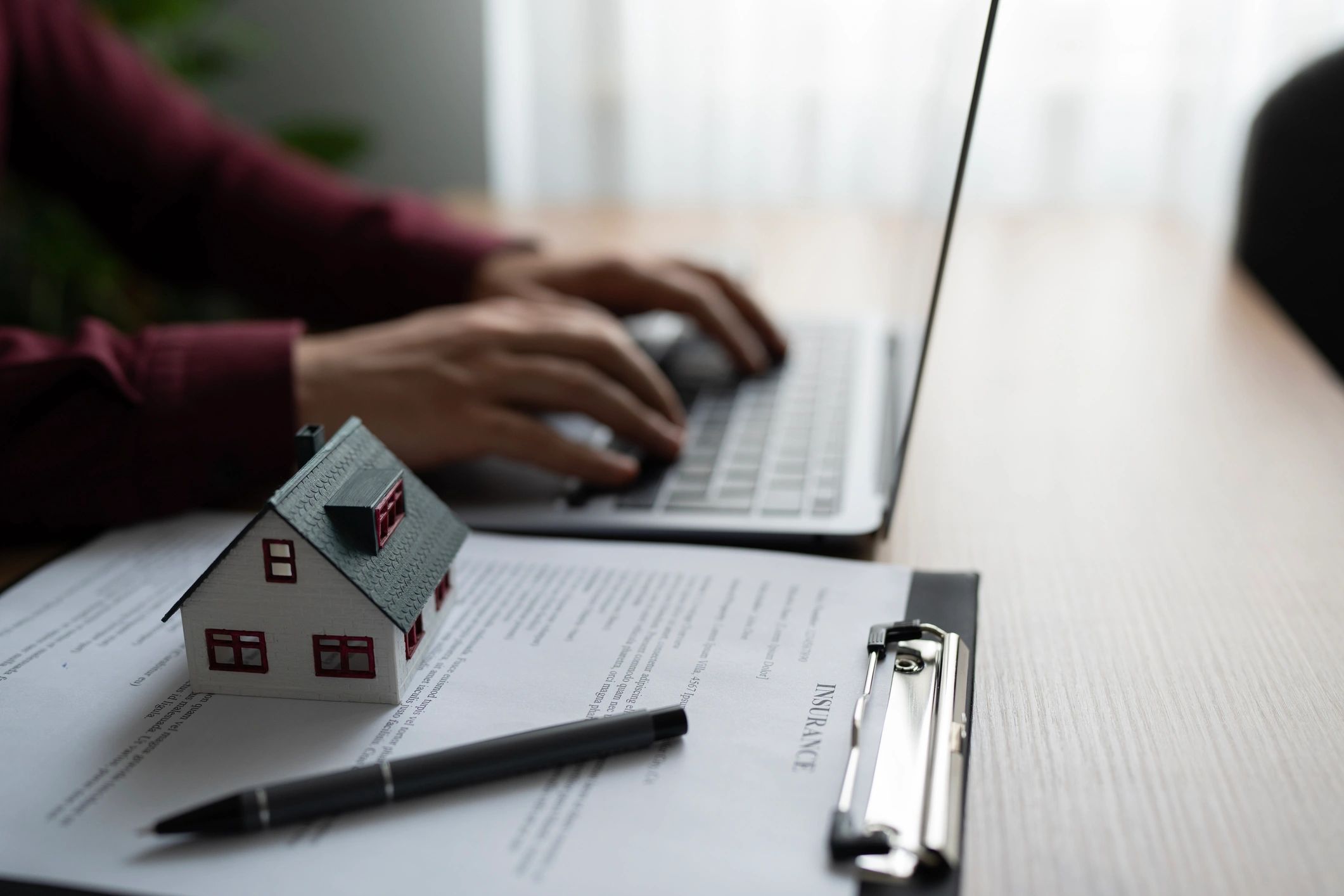 Insurance document and house model on a desk